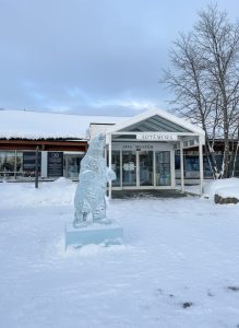 Entrance to the Alta Museum surrounded by snow with an ice sculpture standing outside.