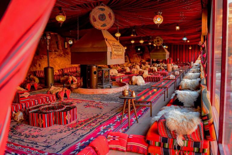 Traditional Bedouin lounge with colourful carpets and comfortable seating at Little Petra Bedouin Camp.