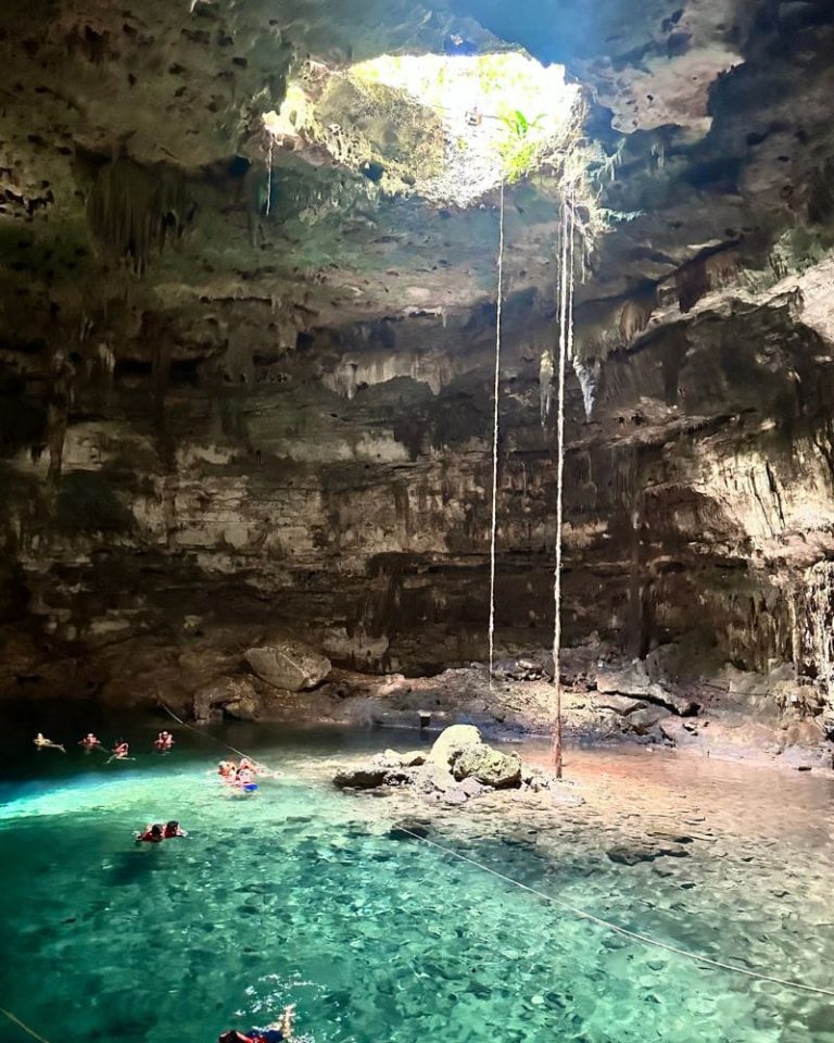 cenote-samula-yucatan Crystal clear water inside Cenote Samulá with sunlight streaming through the cave opening above.