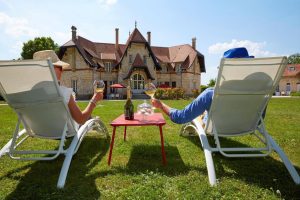 Guests relaxing on sun loungers with Champagne overlooking a countryside estate