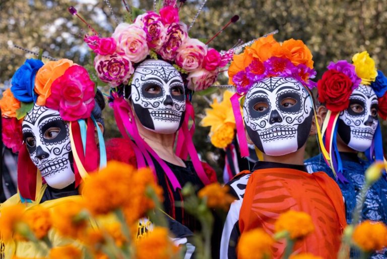 day-of-the-dead-catrina-face-paint People wearing colourful Catrina face paint and floral headdresses during Day of the Dead celebrations in Mexico.