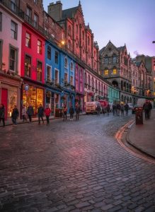 Colourful buildings lining Victoria Street in Edinburgh's Old Town at dusk.