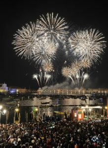 Spectacular fireworks lighting up the Venice lagoon during the Festa del Redentore with crowds gathered along the waterfront and boats filling the water.