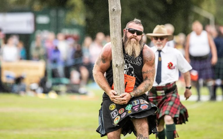 highland-games-caber-toss-scotland Competitor competing in the caber toss at a Scottish Highland Games