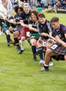 Competitors in kilts take part in the tug of war during a traditional Scottish Highland Games.