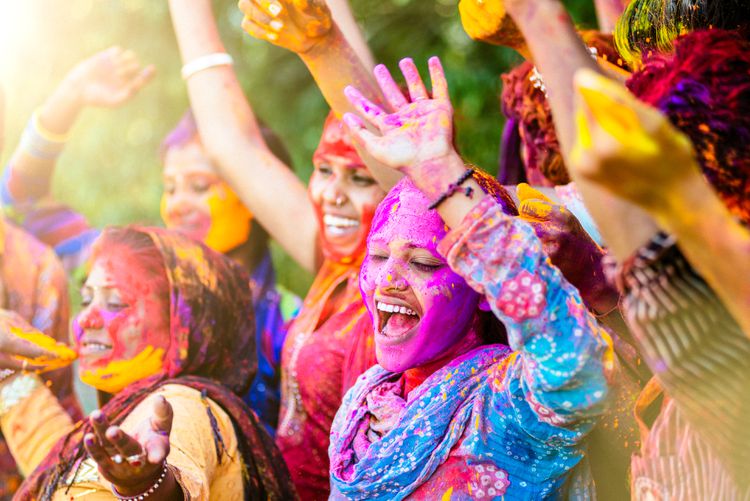 People covered in colourful powder celebrating Holi Festival in India