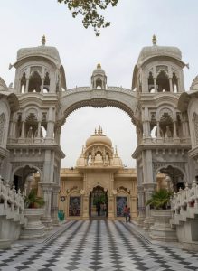 Entrance courtyard of Krishna Janmabhoomi Temple in Mathura with ornate marble architecture and symmetrical archways.