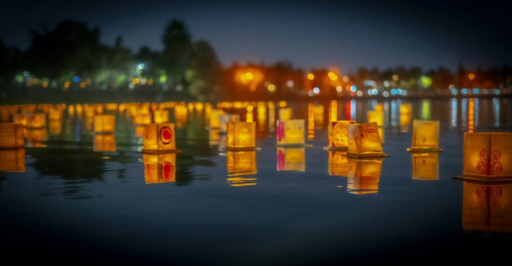 Floating lanterns glowing on the water during Loy Krathong Festival in Thailand
