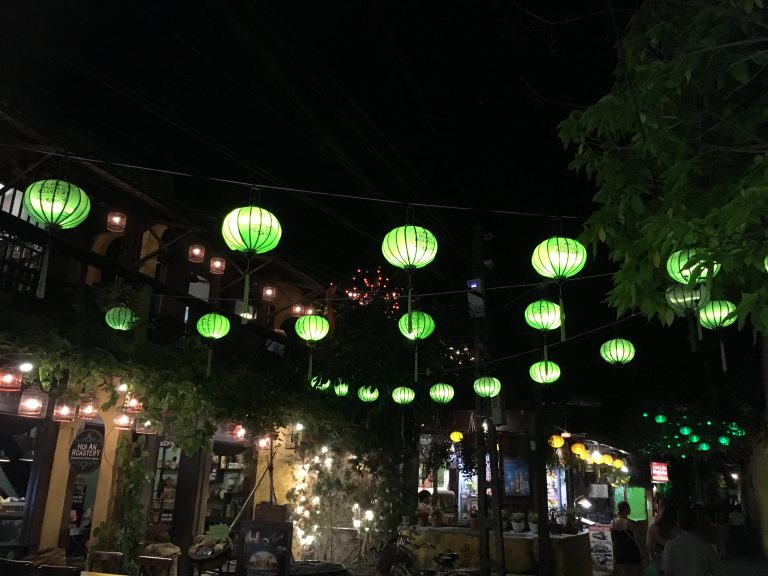Green lanterns illuminating street in Hội An Vietnam at night