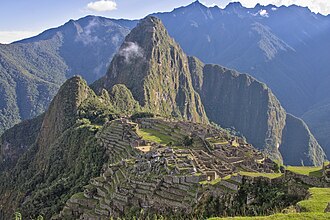 Panoramic view of the ancient Inca citadel of Machu Picchu surrounded by Andean mountains.