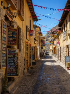 Colourful street in Ollantaytambo with Inca stone walls, colonial buildings and festive bunting in Peru's Sacred Valley