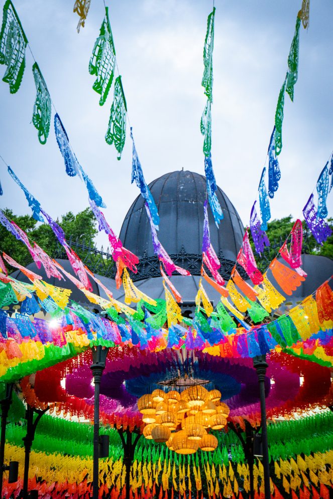Colourful papel picado banners decorating a plaza during Day of the Dead celebrations in Mexico.
