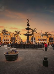 Plaza Mayor in Lima's historic centre at sunset with colonial architecture and central fountain.