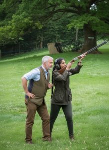 Guest learning clay pigeon shooting with an instructor on a Scottish country estate.