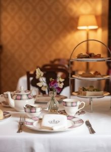 Traditional afternoon tea with sandwiches, cakes and tea served on a tiered stand.