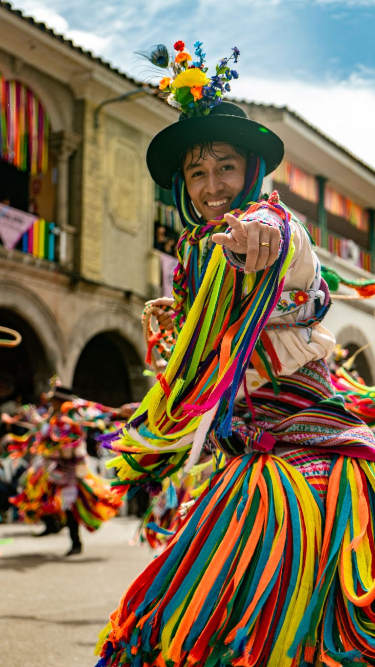 Performer in colourful traditional Andean costume during a cultural celebration in Cusco, Peru.