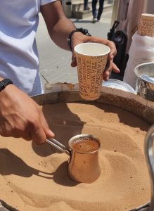 Traditional Arabic coffee being freshly prepared in hot sand during a local coffee experience in Amman.