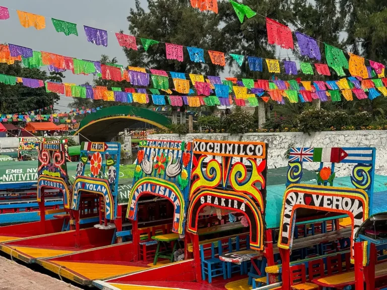 xochimilco-trajineras-mexico-city Colourful trajinera boats decorated with bright papel picado in the canals of Xochimilco, Mexico City.
